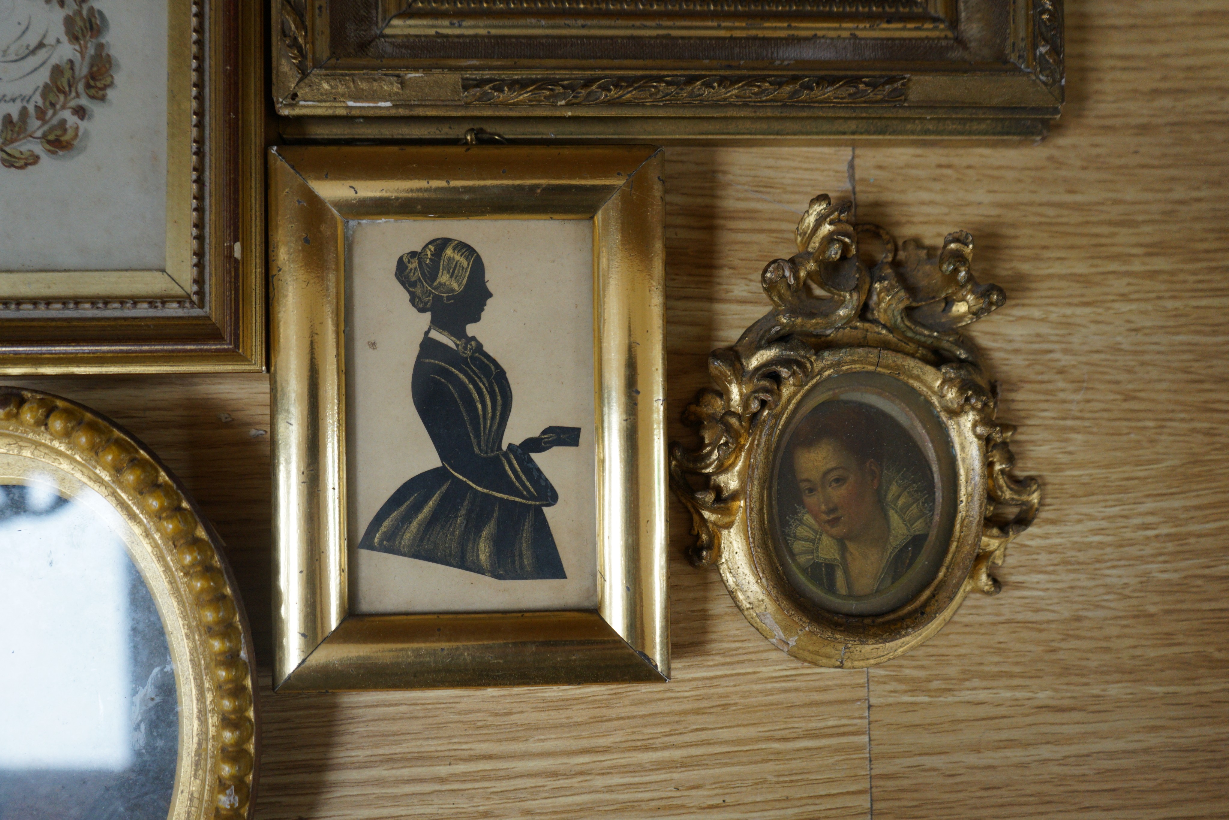 Victorian School, two bronzed cut paper silhouettes of Miss Rogers, Granny Hopegood's nurse 1854, 10 x 6cm, two other miniatures, a small watercolour of a Country House called Blickling, 18 x 13cm and an illuminated Arms